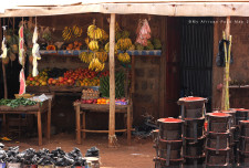 Fruit stand with plantain and sukuma (kale), amongst other things. The black metal objects are little charcoal-fueled stoves. It's called a Jiko and lots of Kenyans use this to cook on.